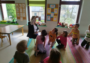 Pani Aleksandra pokazuje dzieciom z grupy "Skrzatów" obrazek z bajki "Pszczółka Maja".