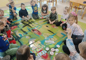 Dzieci z grupy "Biedronek" wspólnie zastanawiają się, jak poprawnie ułożyć piramidę zdrowego żywienia i stylu życia.