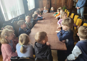 Dzieci siedzą przy ogromnym stole.