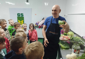 Pan Prezes Zarządu GS Ozorków prezentuje dzieciom, jak zrobić warzywnego gołąbka.