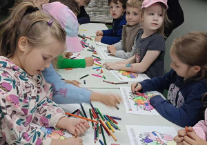 "Biedronki" podczas kolorowania szablonu warzyw i owoców.