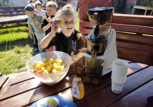 Oliwia podczas przygotowania naturalnego soku jabłkowo-marchewkowego.