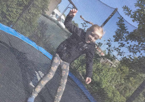 Oliwia skacze na trampolinie.