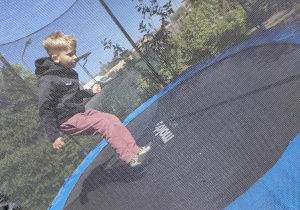 Artur skacze na trampolinie.