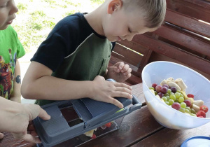 Kuba S. w trakcie przygotowania sałatki owocowej w altance ogrodowej.