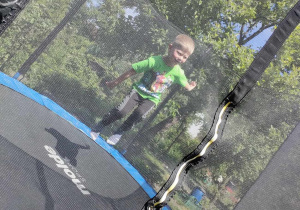 Tymon skacze na trampolinie.