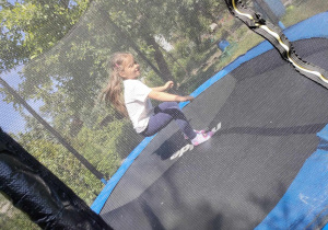 Maja skacze na trampolinie.