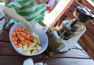 Gabryś w trakcie przygotowywania naturalnego soku jabłkowo-marchewkowego w ogrodowej altance.