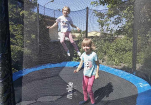 Zosia i Magda skaczą na trampolinie.