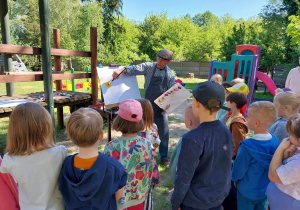 Pan Paweł tłumaczy dzieciom zasadę mieszania farb i powstawania nowych kolorów.