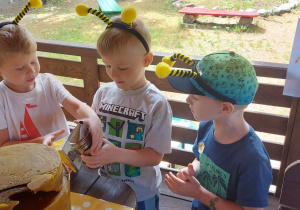 Kilkoro dzieci z grupy "Biedronek" poznają sprzęt pszczelarski.