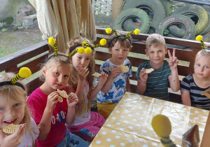 Kilkoro dzieci z grupy "Biedronek" podczas degustacji miodu na kruchych wafelkach.