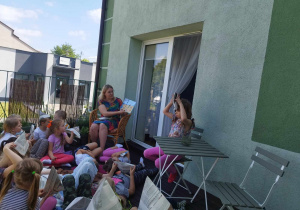 Pani Ola czyta książkę o Bolku i Lolku. Wszyscy znajdują się na tarasie biblioteki.