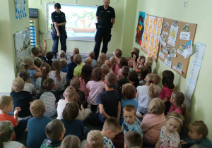 Funkcjonariusze Policji rozmawiają z dziećmi starszymi nt. bezpieczeństwa podczas wakacji.