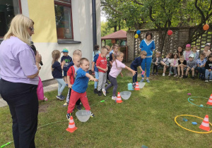 Dzieci z trzech, starszych grup w trakcie konkurencji sportowej - "Rzuć do celu".