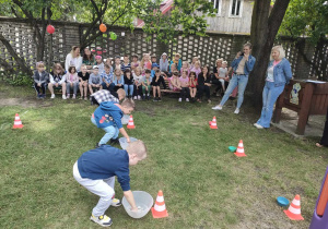 Dzieci z trzech, starszych grup w trakcie konkurencji sportowej - "Łowimy kamyczki".