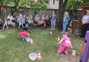 Dzieci z trzech, starszych grup w trakcie konkurencji sportowej - "Łowimy kamyczki".