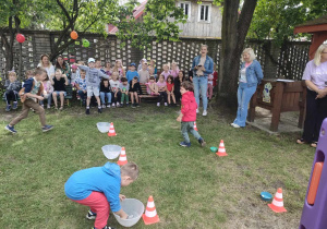 Dzieci z trzech, starszych grup w trakcie konkurencji sportowej - "Łowimy kamyczki".