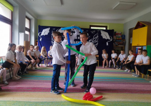 Dzieci z pomocą balonów ilustrują wiersz J. Tuwima pt. "Abecadło".