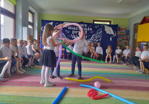 Dzieci z pomocą balonów ilustrują wiersz J. Tuwima pt. "Abecadło".