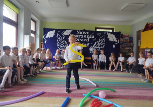 Dzieci z pomocą balonów ilustrują wiersz J. Tuwima pt. "Abecadło".