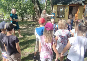 P. Basia zaprasza dzieci do zwiedzania leśnej chatki.