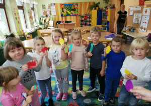 Dzieci z grupy "Wiewiórki" prezentują papierowe owoce przed zabawą "Sałatka owocowa"