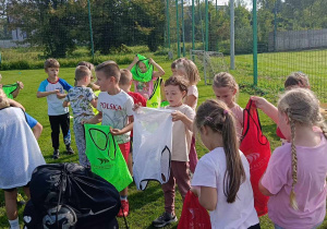 Dzieci z grupy "Biedronek" zakładają kolorowe znaczniki, potrzebne do rozegrania meczu.