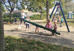 Dwoje dzieci na "konikach" na placu zabaw w Parku Miejskim.