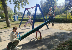 Dwóch chłopców na "konikach" na placu zabaw w Parku Miejskim.