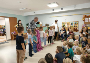 Pan Witek rozśmiesza dzieci, przymierzając im magiczne spodnie.