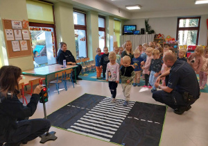 Dzieci ćwiczą prawidłowe przejście przez jezdnię.