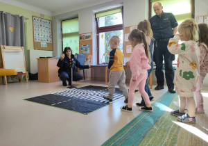 Dzieci ćwiczą prawidłowe przejście przez jezdnię.