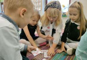 Zespół dzieci układa domino patriotyczne w kształt prostokątu.