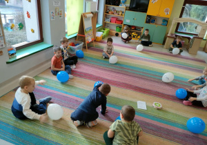 Zabawy ruchowe z balonami - przy podwójnym uderzeniu w bębenek, dzieci siadają skrzyżnie obok swojego balona.