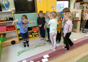 Dzieci w zespołach wykonują ćwiczenie na danej stacji - skoki przez skakankę.