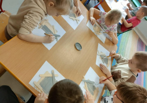 Kilkoro dzieci z grupy "Pszczółek" maluje farbą sklejone, drewniane patyczki.