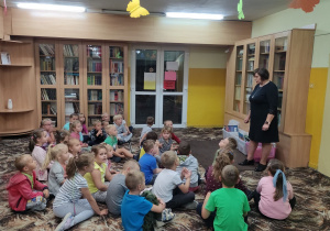 Dzieci z grupy "Skrzaty", "Wiewiórki", "Kaczuszki", słuchają ciekawostek związanych z biblioteką