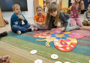 Dziewczynka rozwiązuje działanie matematyczne, po czym szuka cyfry, która jest wynikiem.