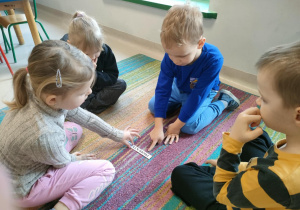 Dzieci w zespole odczytują napisy na wybranym przez siebie pasku.
