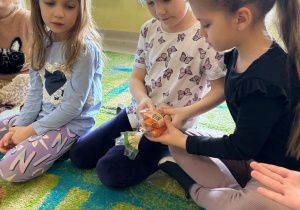 "Biedroneczki" przyglądają się znaczkowi, który znajduje się na opakowaniu ekologicznych mini-marchewek.