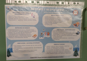 Plakat informacyjny "Zdrowo i bezpiecznie podczas ferii zimowych" przyczepiony na holu.