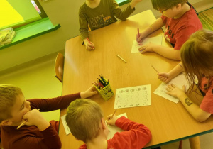 Kilkoro dzieci z grupy "Pszczółek" podczas rozwiązywania wybranych przez siebie, walentynkowych kart pracy.