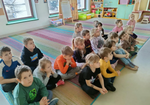 Dzieci z połączonych grup: "Pszczółek" i "Motylków" oglądają film edukacyjny nt. tłustego czwartku na ekranie multimedialnym.