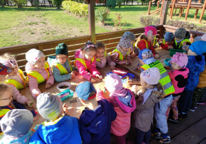 Dzieci wykonują pracę plastyczną w ogrodzie przedszkolnym