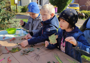 Dzieci wykonują pracę plastyczną w ogrodzie przedszkolnym