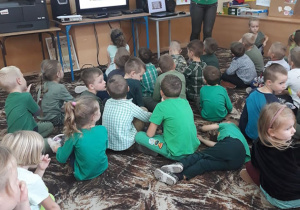 Dzieci oglądają obraz Drzewo życia G. Klimta i uważnie słuchają ciekawostek o tym obrazie