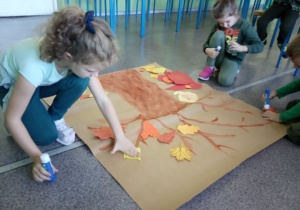 Dzieci z "Kaczuszek" ozdabiają sylwetę swojego drzewa życia