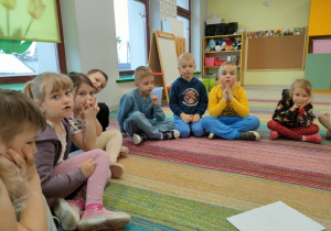 Dzieci siedzą w kole i odpowiadają na pytania, związane z treścią bajki.