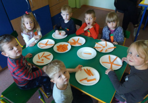 Dzieci z "Biedronek" układają kompozycje z marchewek na talerzykach papierowych